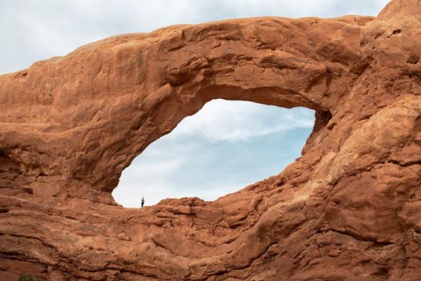 women standing in window arch in Arches National Park in Utah