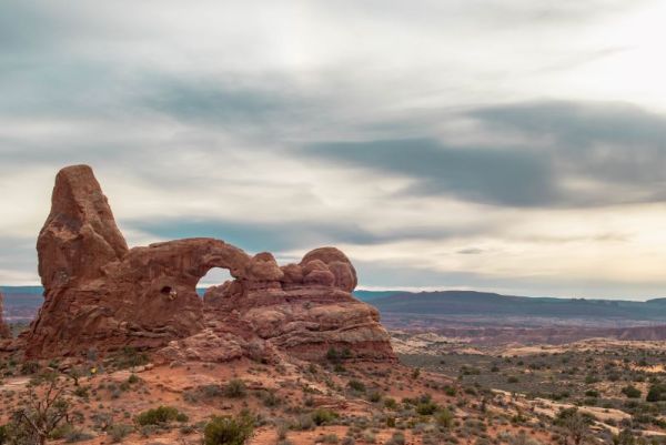 rock arch and formation in desert at sunset