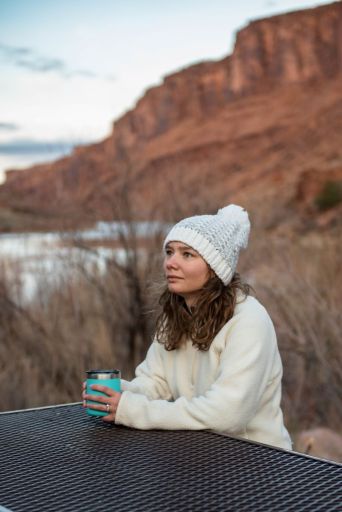 girl in white jacket and hat at campsite near Moab Utah