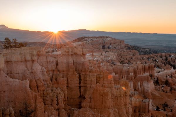 sunrise at bryce canyons with orange rock hoodoos and orange sky