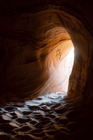 light shining onto sand in cave