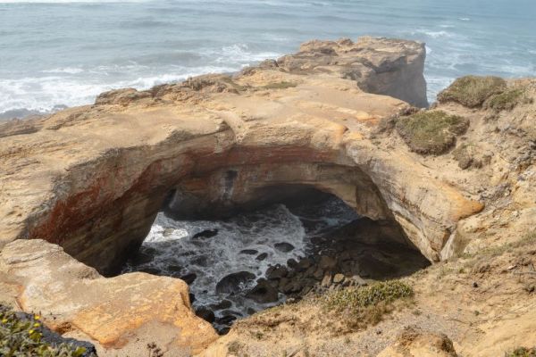 The Devil's Punchbowl on the Oregon Coast with waves coming in