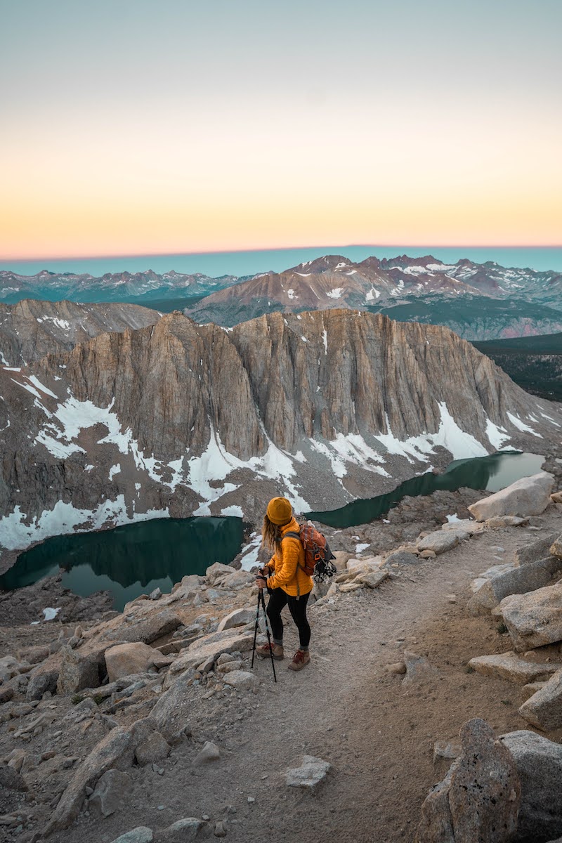 girl in yellow jacket looking down from Trail Crest trail leading to Mount Whitney