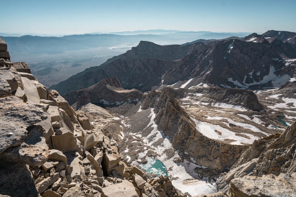 views of bright blue lake and mountains from the summit of Mount Whitney