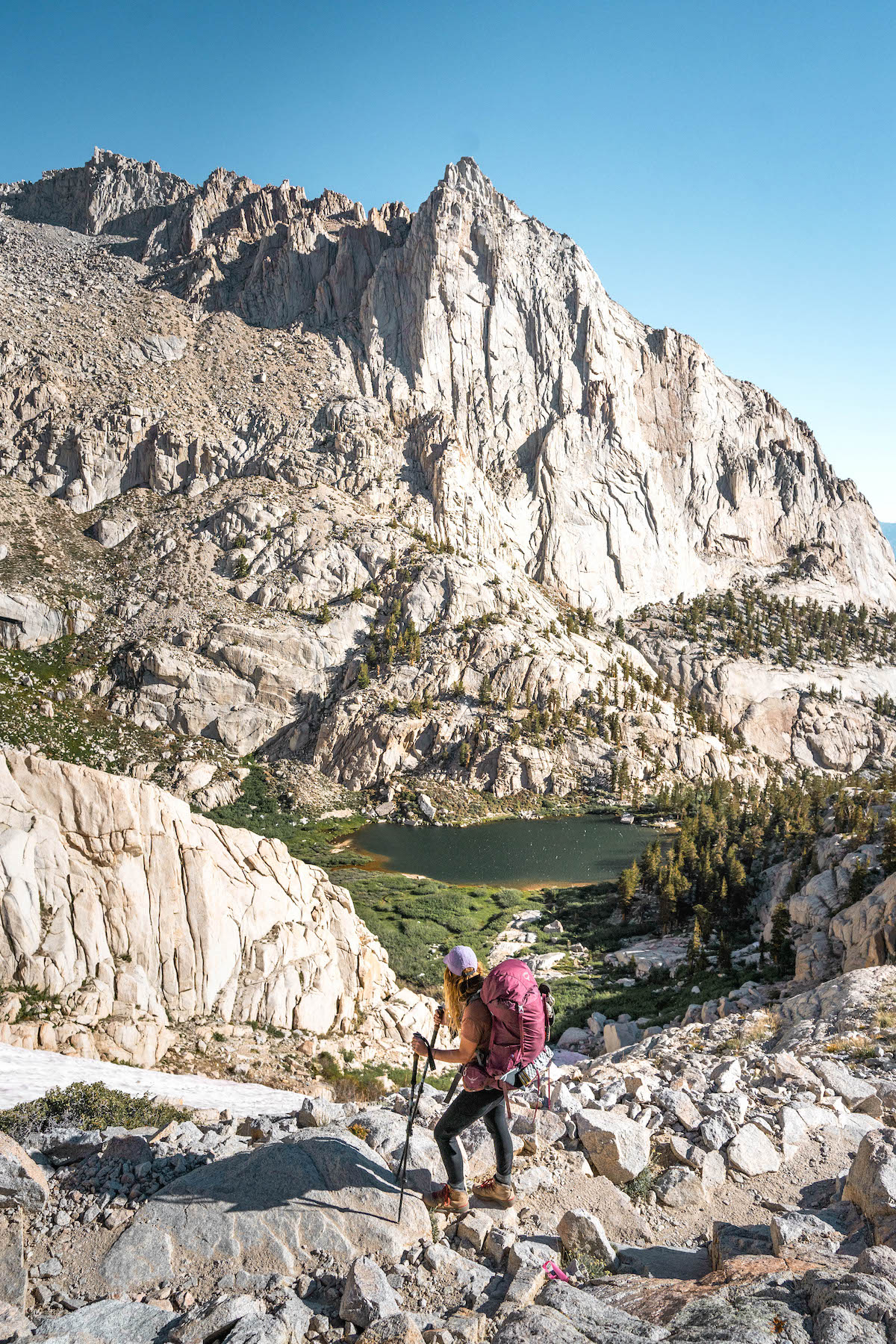 girl in pink backpack Backpacking up Mount Whitney looking down to Mirror Lake