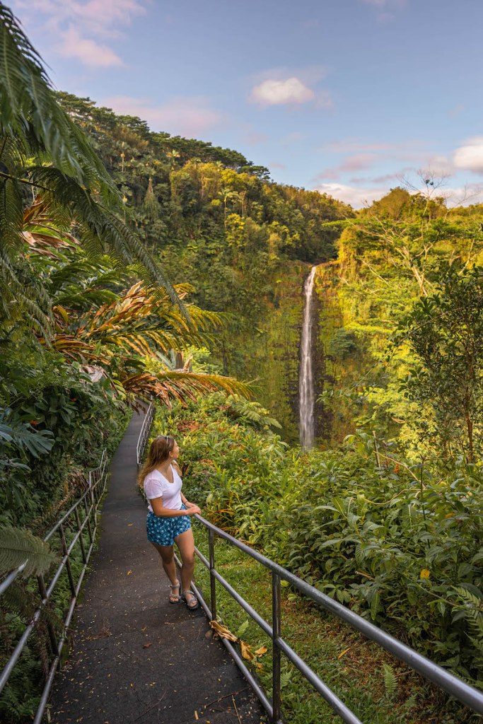 girl in shorts and shirt looking at Akaka Falls