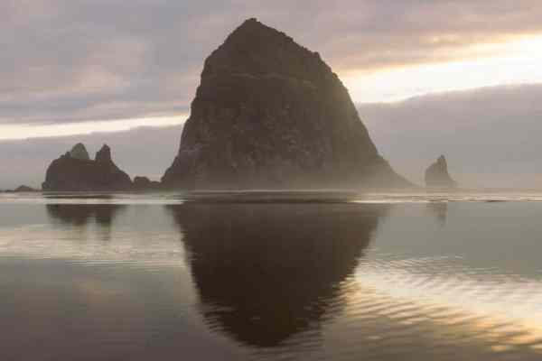 haystack rock and surrounding rocks at sunset on Cannon Beach