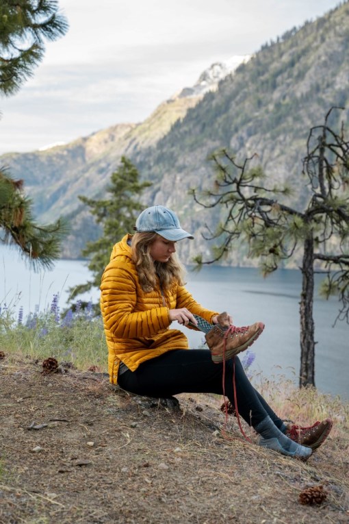 putting hiking insoles into a boot in the mountains