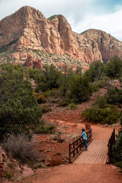 girl on bridge overlooking red rocks in Sedona