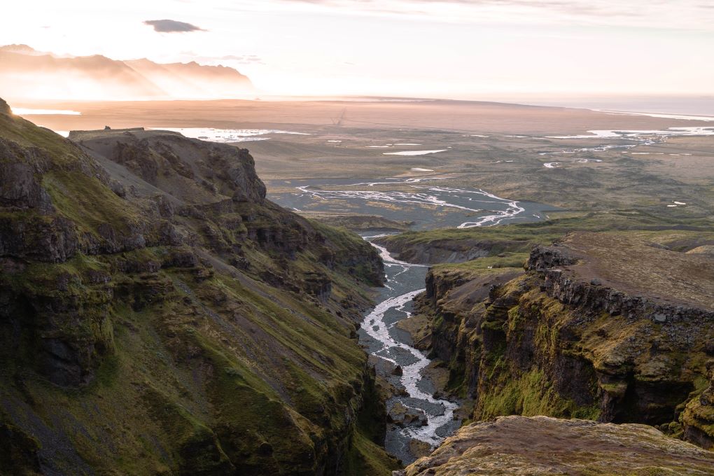 Múlagljúfur Canyon hike in Iceland at sunrise, view of canyon, stream, mountains, and ocean with mist