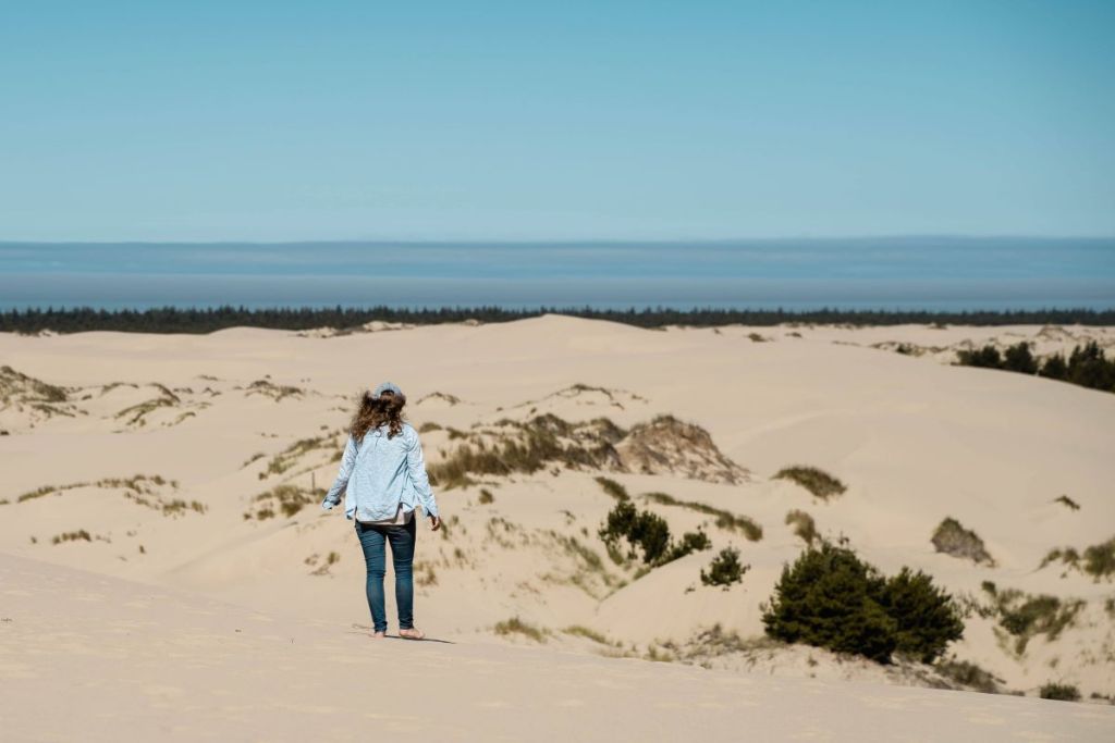 girl in blue hiking on Oregon Sand Dunes on John Dellenback Trail