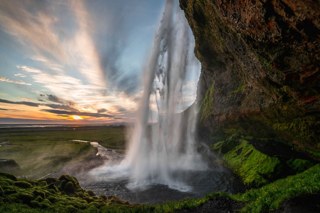 view of sunset from behind Seljalandsfoss