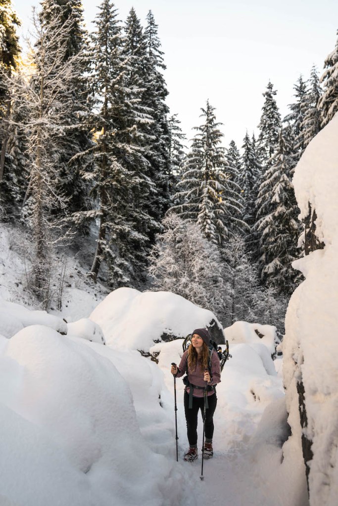 woman in pink hiking in snowy winter forest