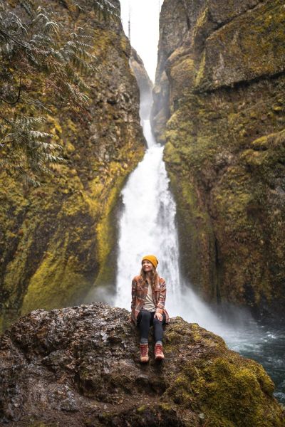 girl in flannel and yellow hat in front of Wahclella Falls