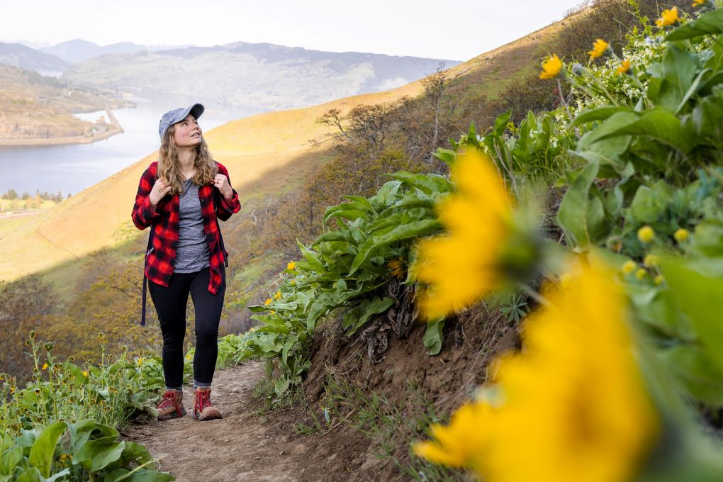 girl hiking on wildflower field path in columbia river gorge